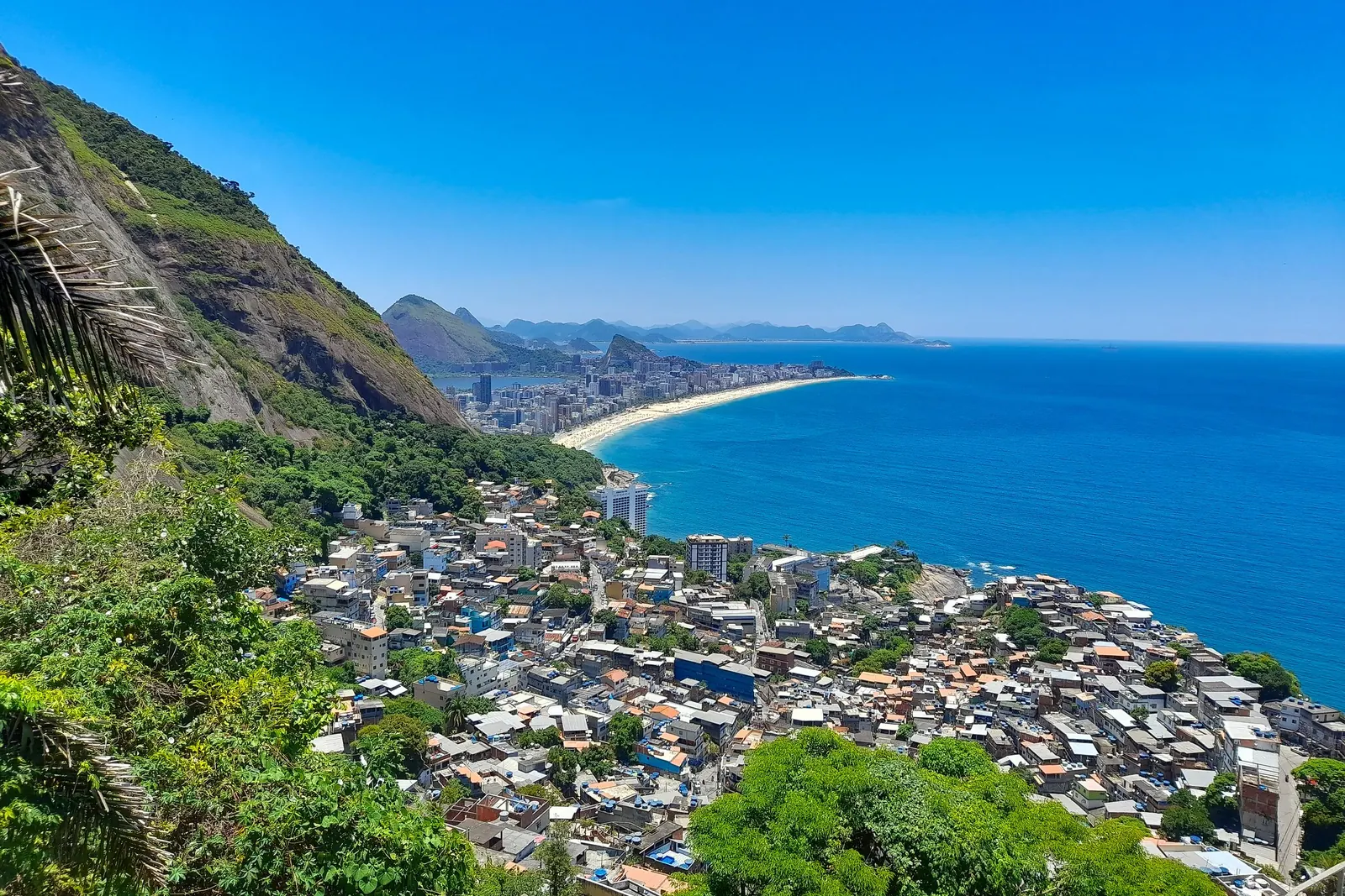Bostadsområden på en grön sluttning ned mot havet i Rio.