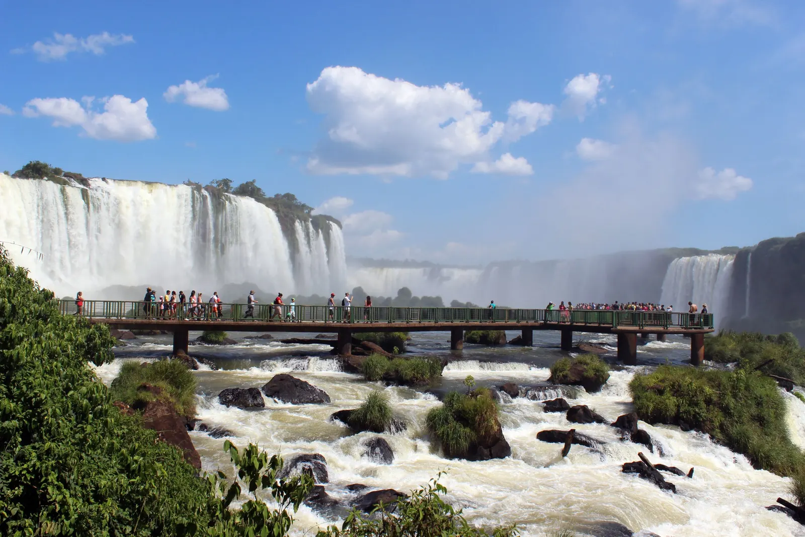 Besökare på en gångbro framför vattenfallen i Iguaçu.